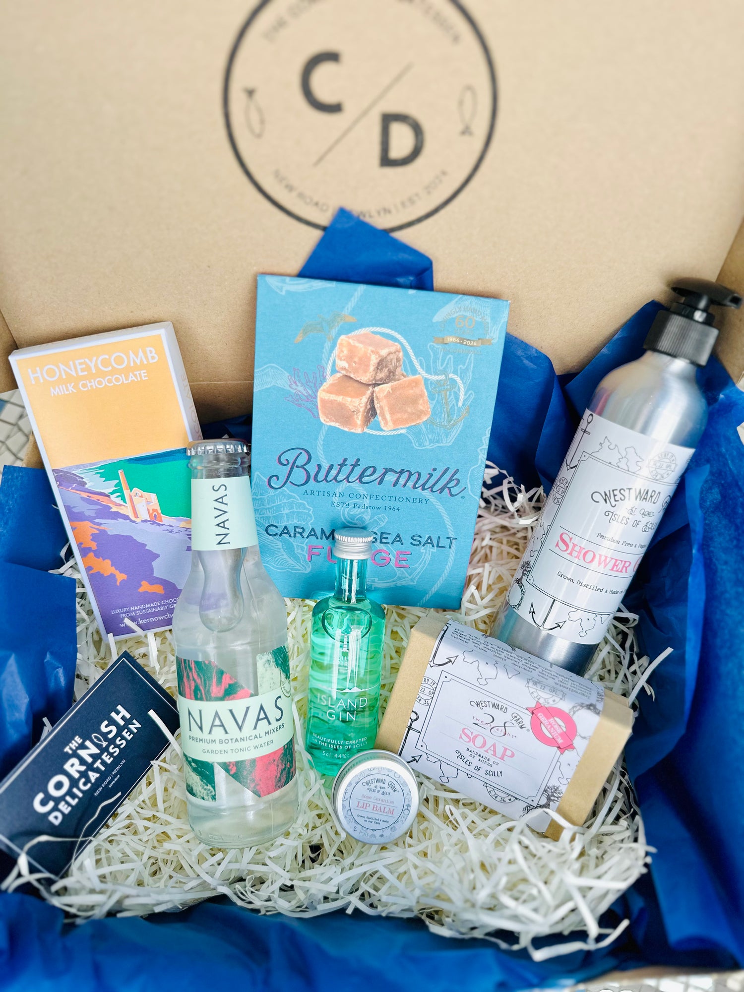Pamper hamper gift box with gifts including chocolate, fudge, soaps and gin and tonic.