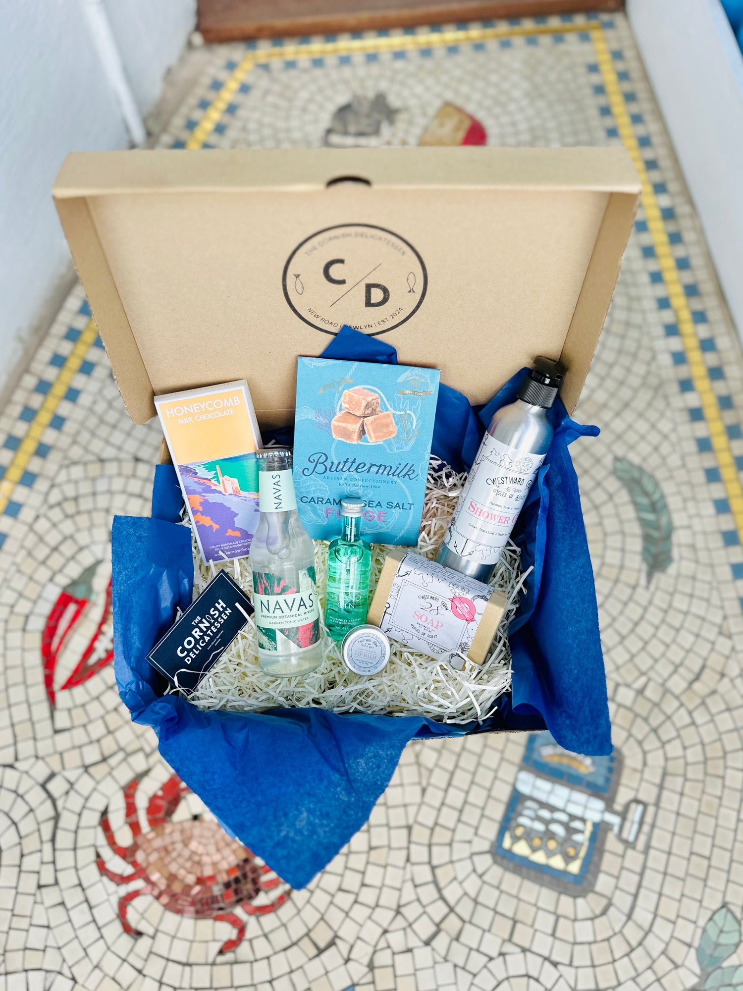 Pamper hamper gift box with gifts including chocolate, fudge, soaps and gin and tonic.